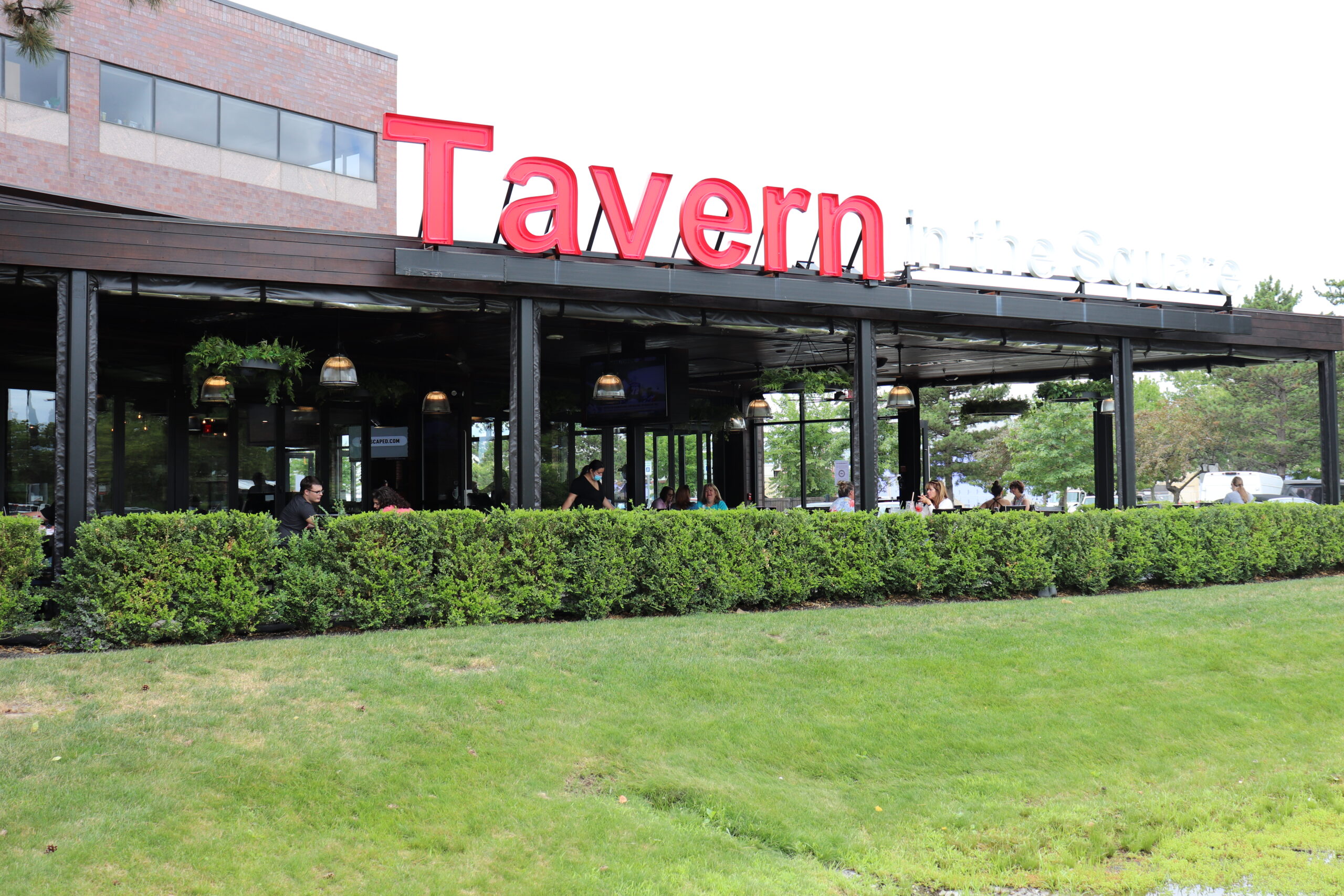 Outdoor seating area of an American Tavern Bar & Restaurant, with a large red 