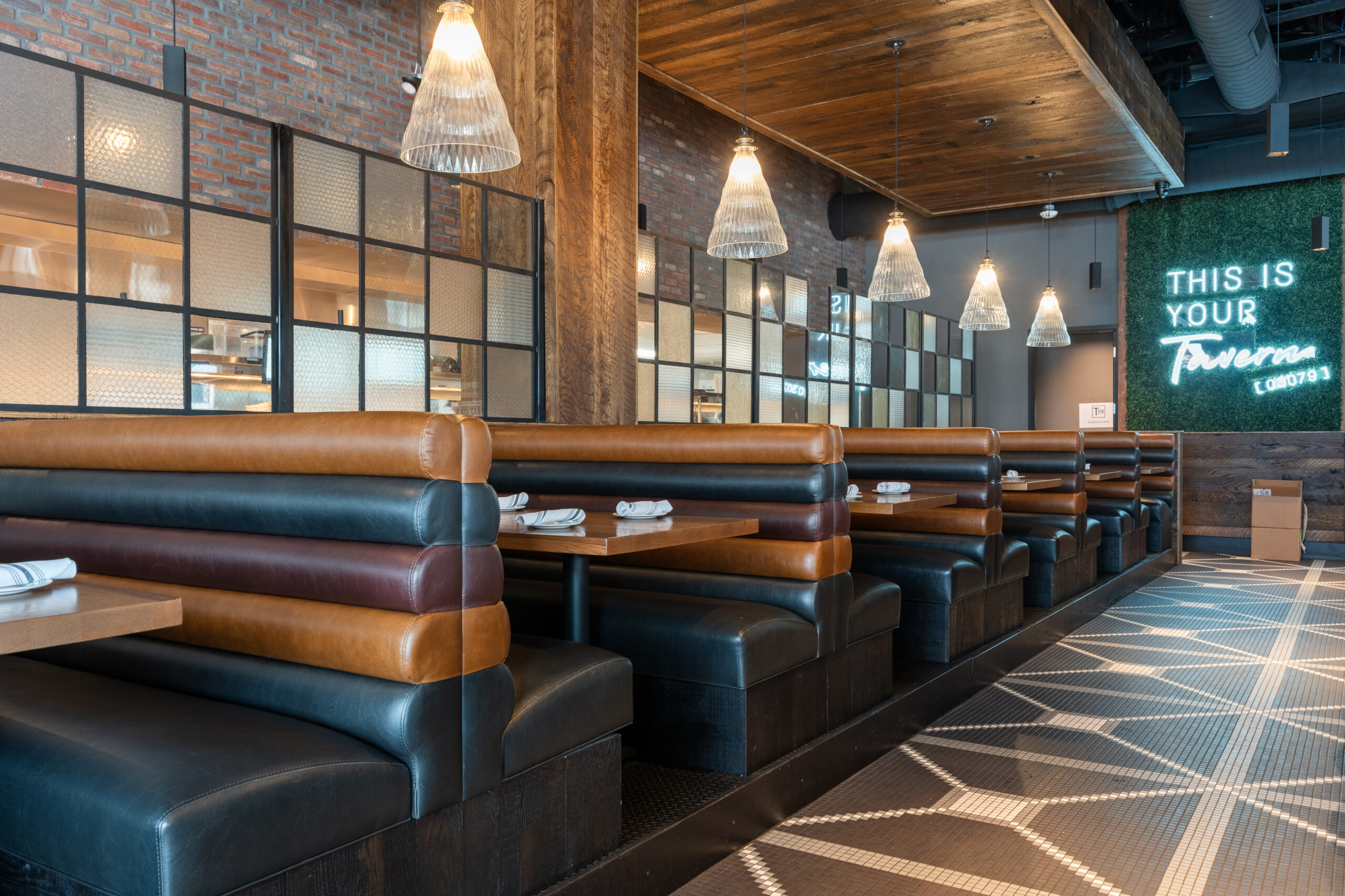 A cozy booth seating in an American Tavern, perfect for relaxing and enjoying your meal at a classic Bar & Restaurant.