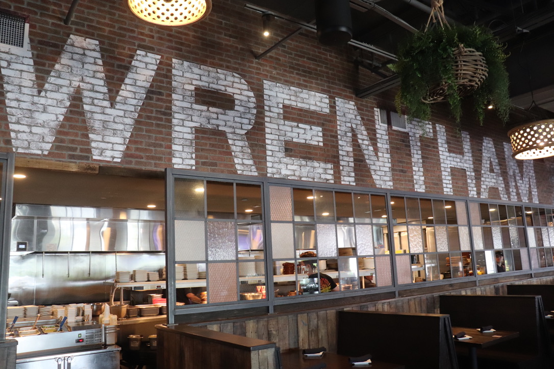 Interior of a Wrentham MA restaurant featuring a brick wall with bold 